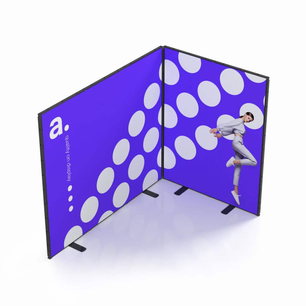 Beursstand Twee verbonden beeldschermpanelen vormen een hoek. Het linkerpaneel is paars met witte stippen, een witte a. en verticale tekst. Het rechterpaneel toont een persoon die springt tegen een paarse achtergrond met witte cirkels.